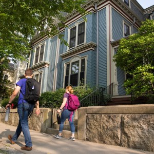 Students walking in front of house.